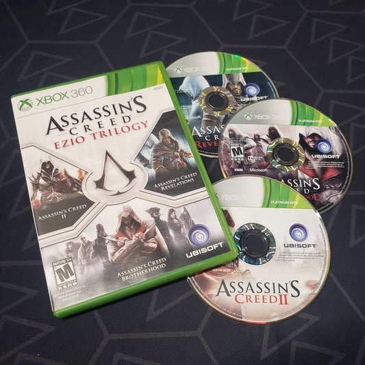 Image shows the case and three discs for the video game Assassin's Creed: Ezio Trilogy for Xbox 360