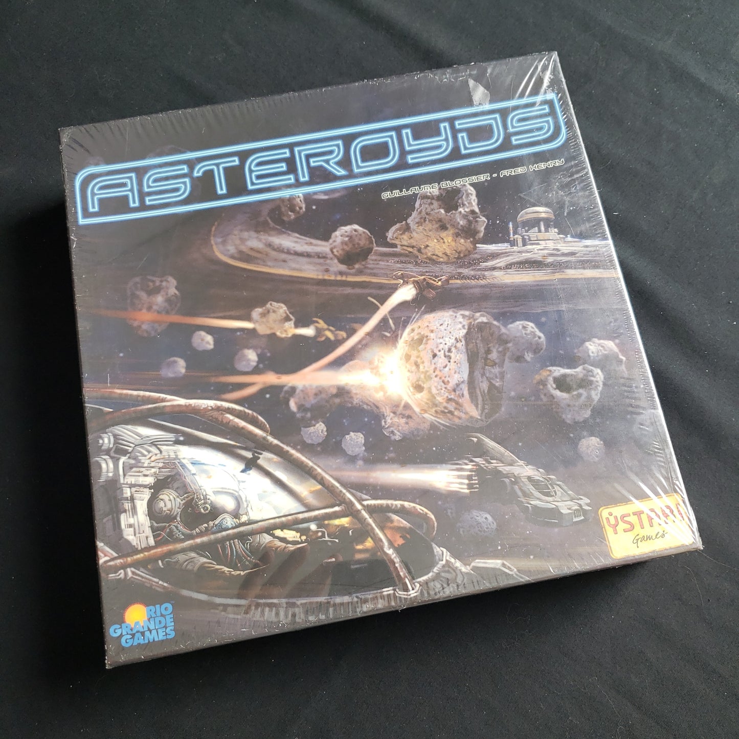 Image shows the front cover of the box of the Asteroyds board game