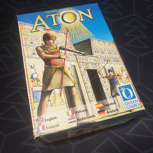 Image shows the front cover of the box of the Aton board game