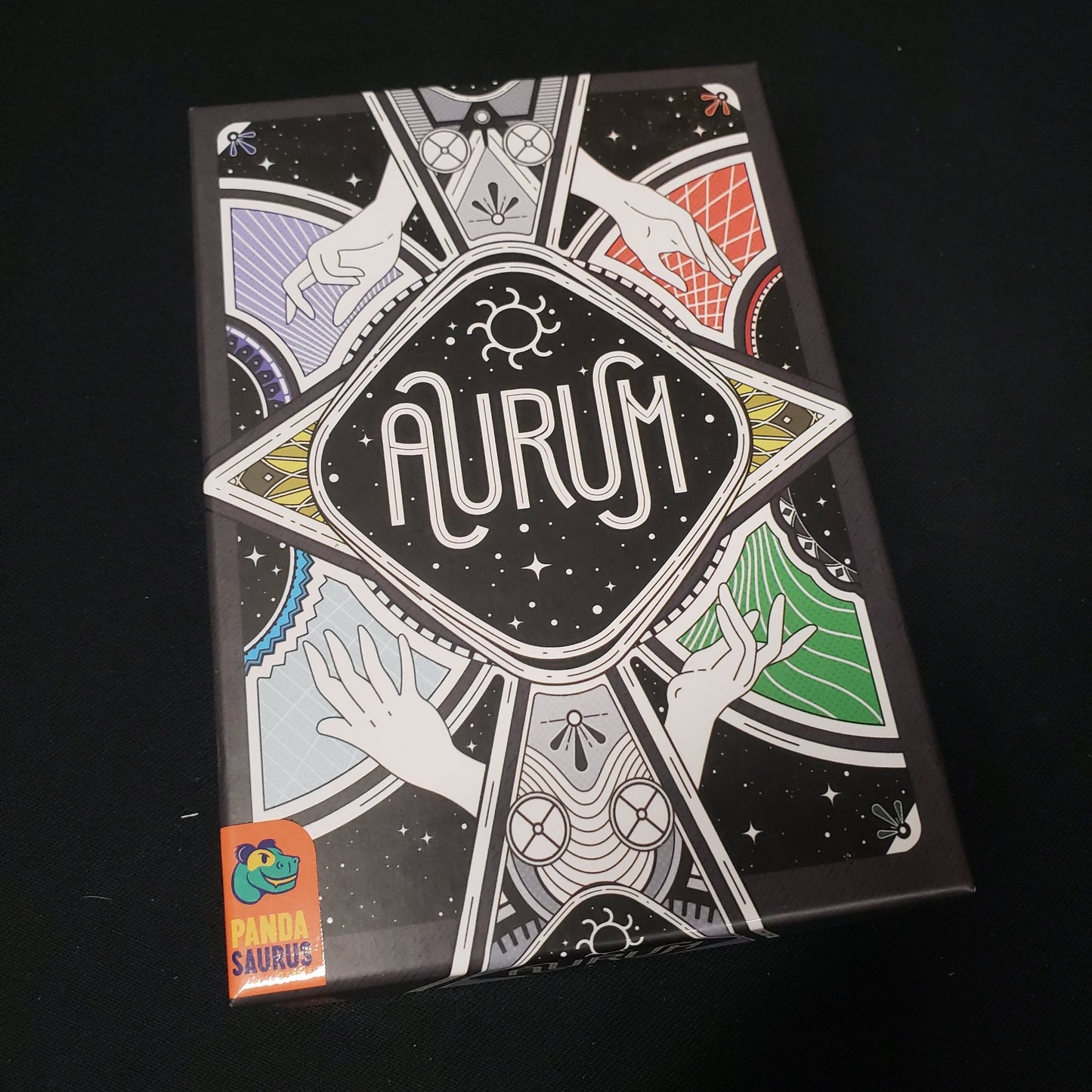 Image shows the front cover of the box of the Aurum card game