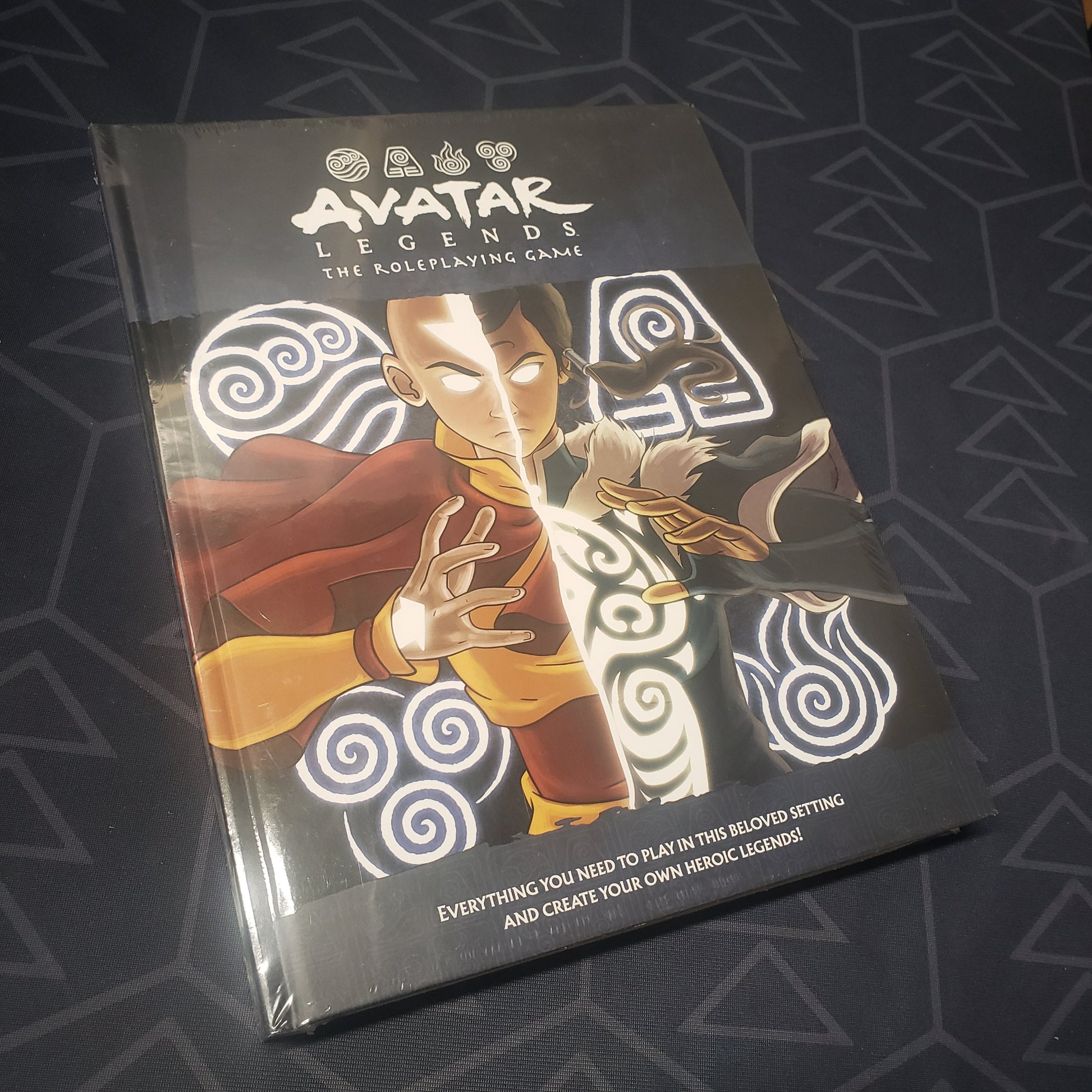 Image shows the front cover of the core rulebook for the roleplaying game Avatar Legends