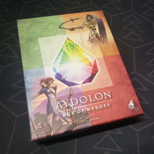 Image shows the front cover of the box for the Aydolon: Age of Heroes card game