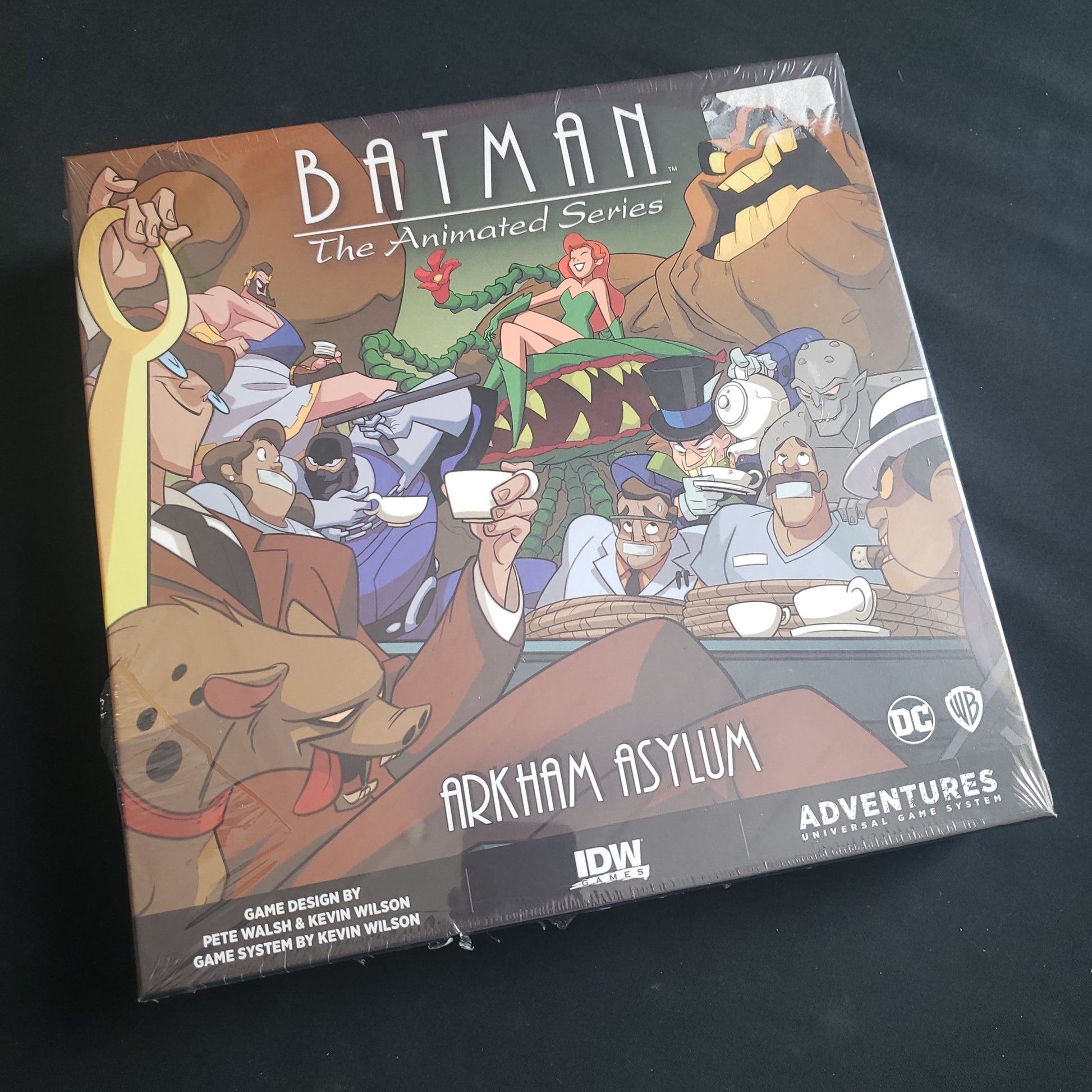 Image shows the front cover of the box of the Arkham Asylum expansion for the board game Batman: The Animated Series Adventures