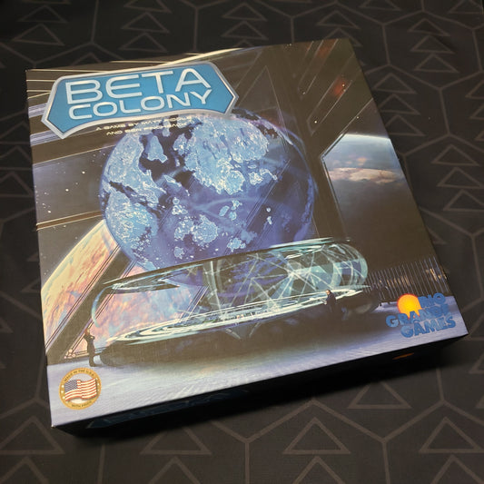 Image shows the front cover of the box of the Beta Colony board game