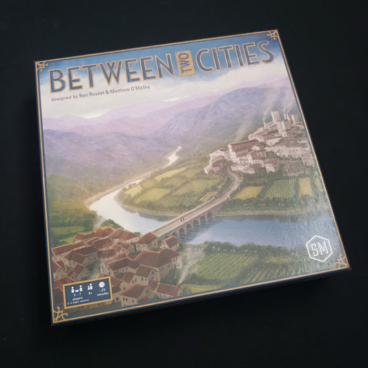 Image shows the front cover of the box of the Between Two Cities board game