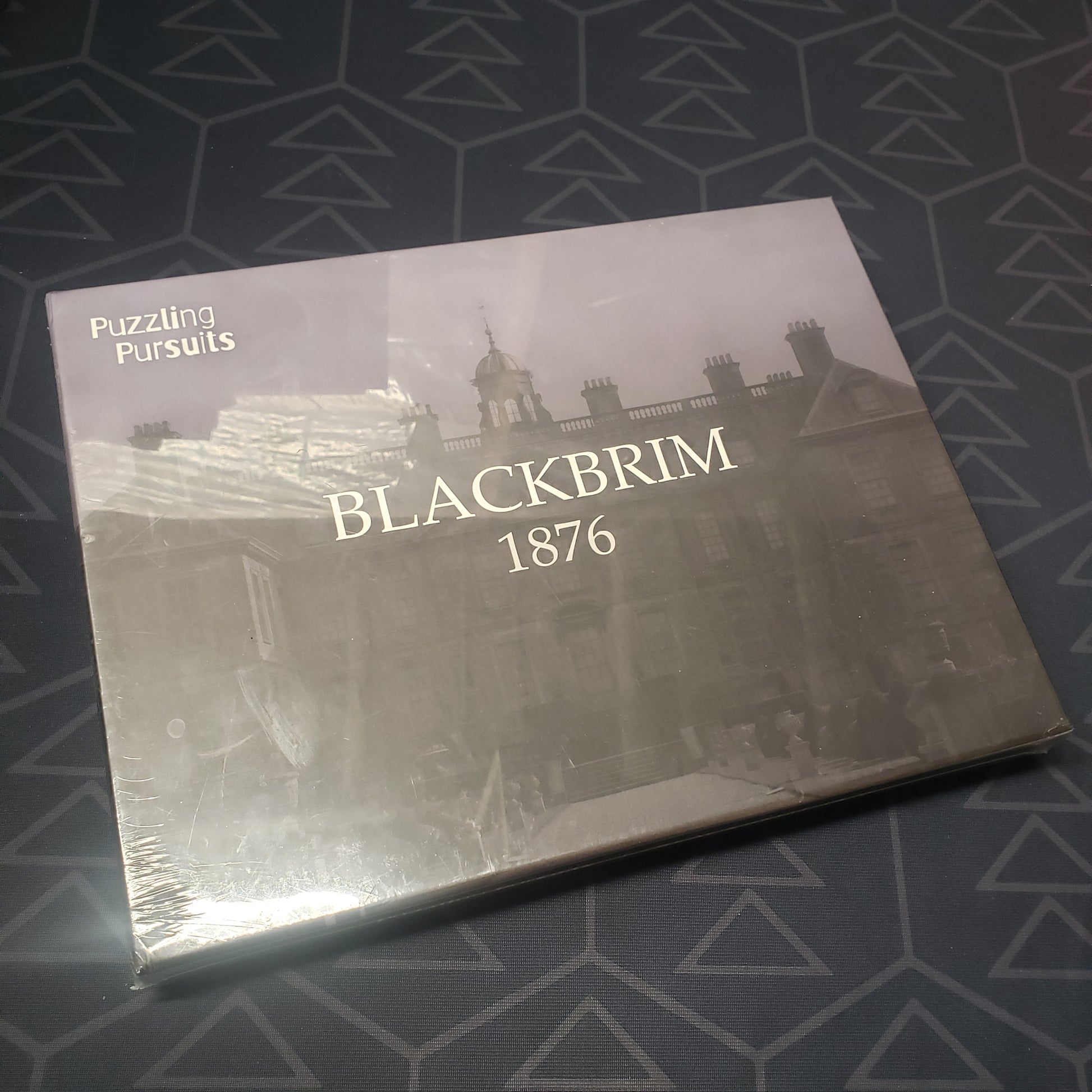 Image shows the front cover of the box for the Blackbrim: 1876 puzzle game