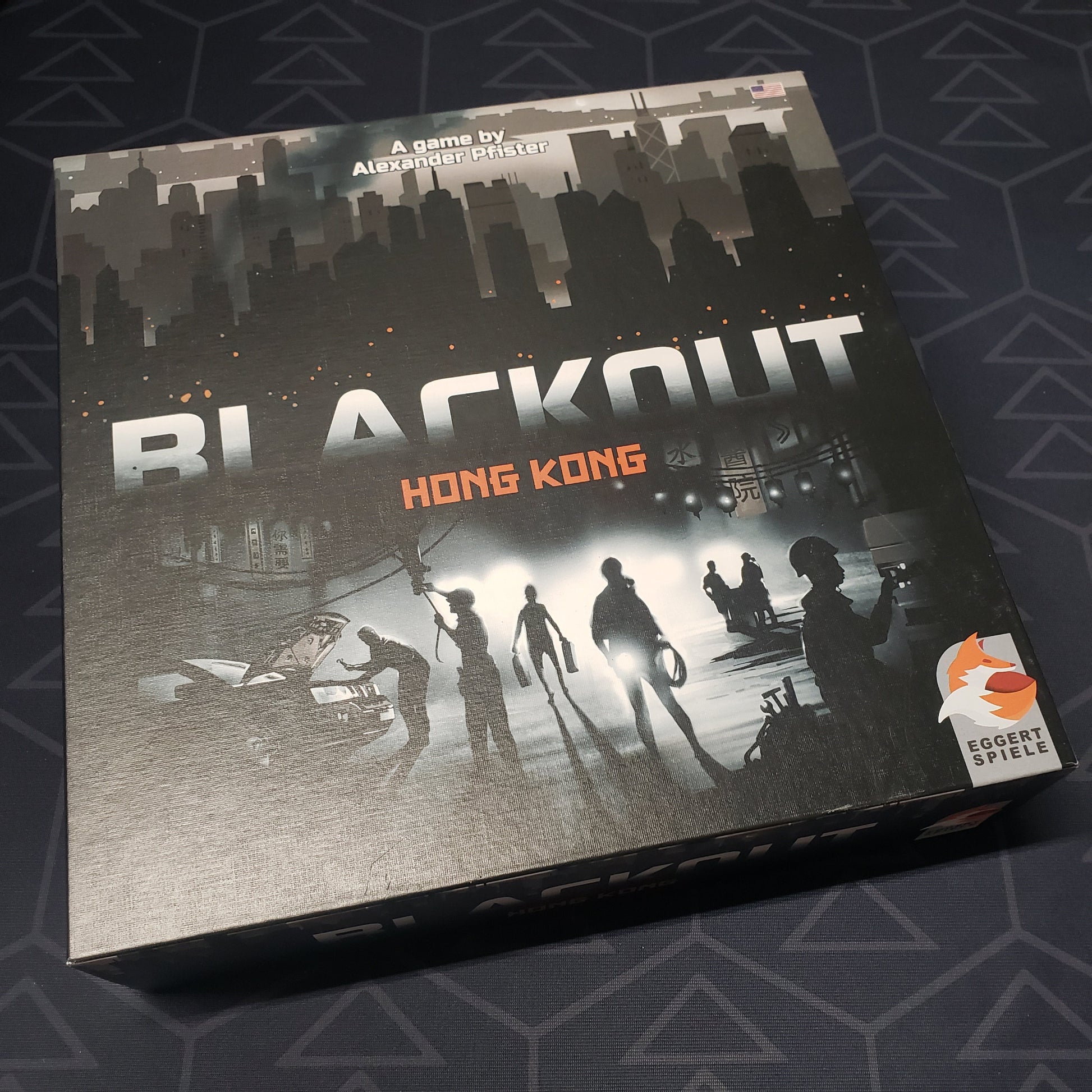 Image shows the front cover of the box for the Blackout: Hong Kong board game