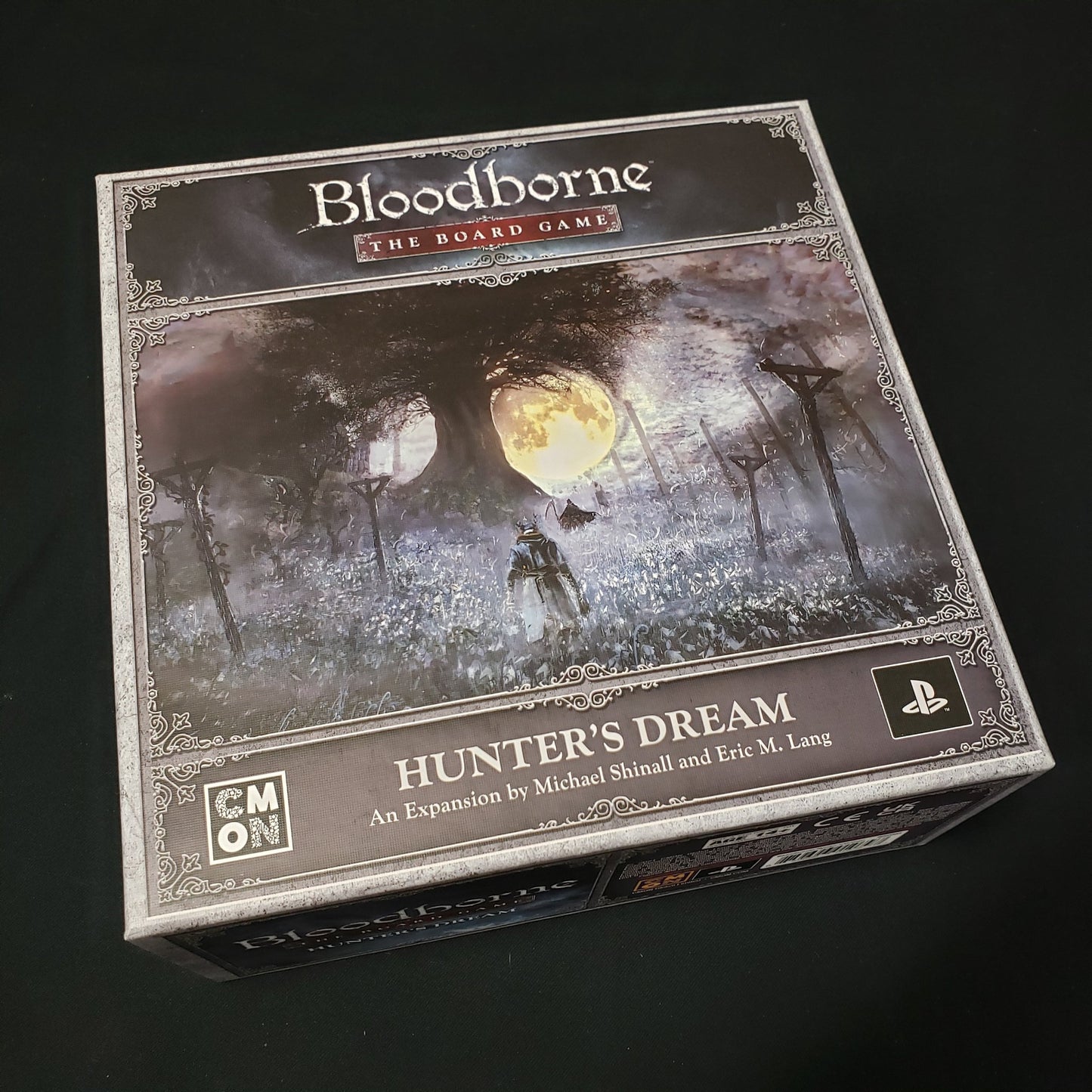 Image shows the front cover of the box of the Hunter's Dream expansion for Bloodborne: The Board Game