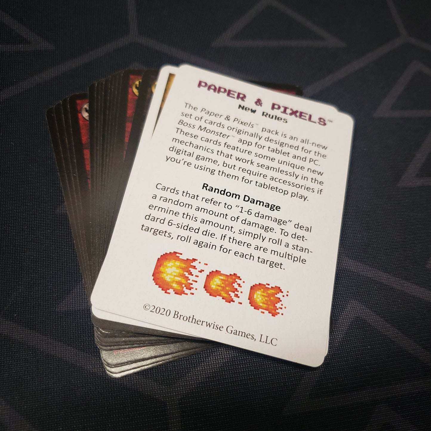 Image shows the fanned-out cards for the Paper & Pixels expansion pack for the card game Boss Monster