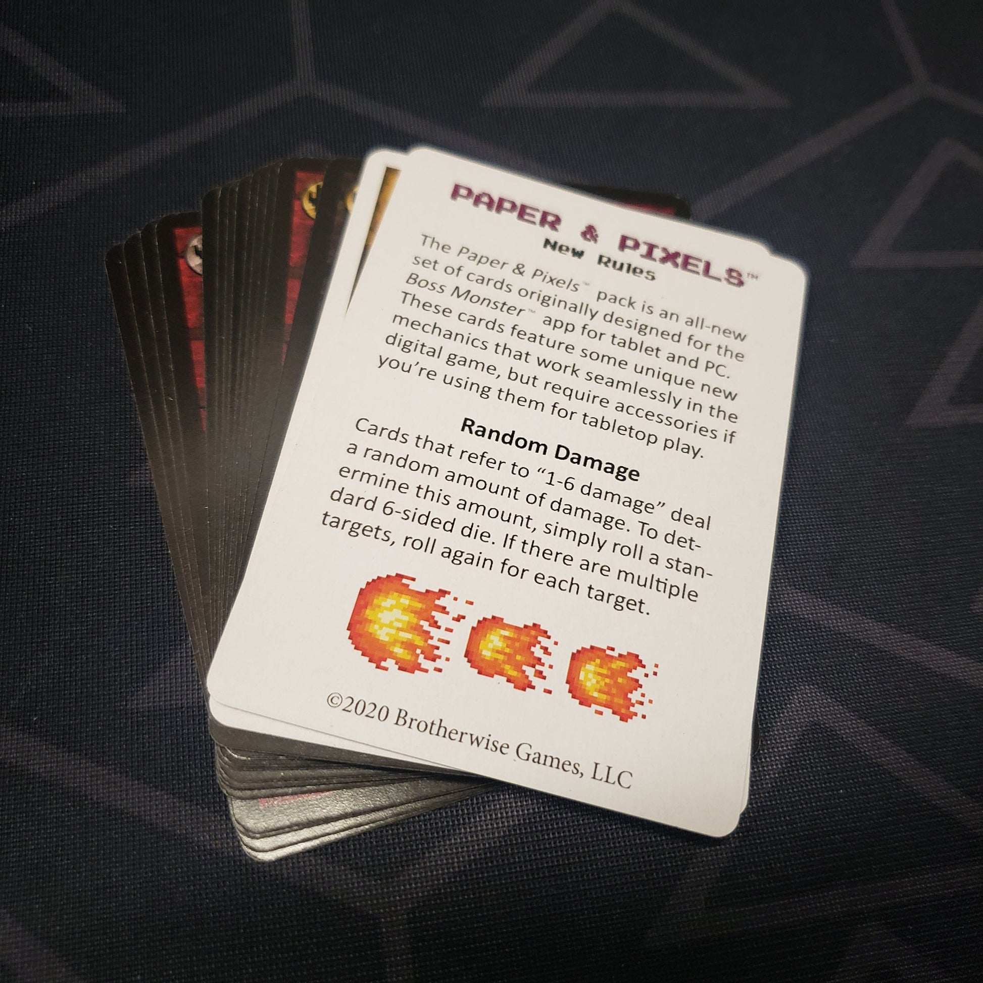 Image shows the fanned-out cards for the Paper & Pixels expansion pack for the card game Boss Monster