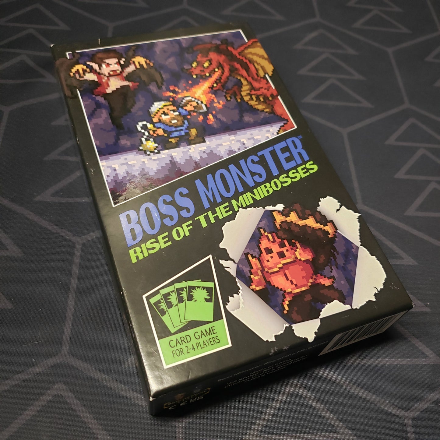 Image shows the front cover of the box for the Boss Monster: Rise of the Minibosses card game