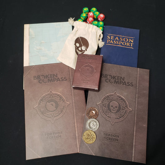 Image shows the Fourtune Master's screen and multiple accessories for the roleplaying game Broken Compass
