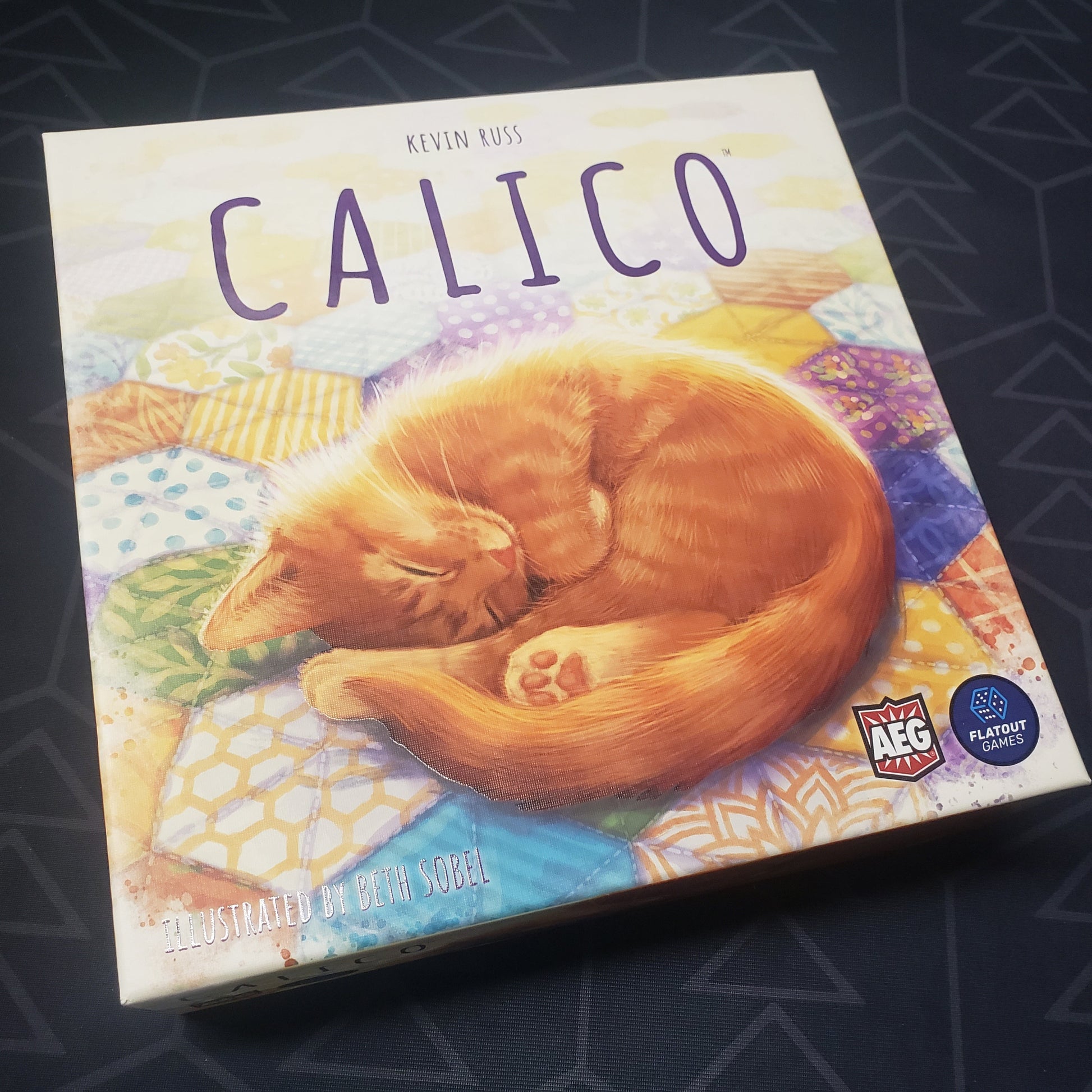 Image shows the front cover of the box of the Calico board game
