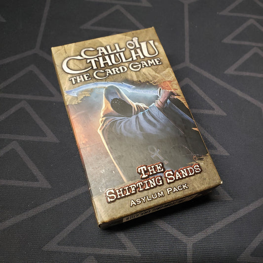 Image shows the front of the box of the Shifting Sands Asylum pack for the card game Call of Cthulhu