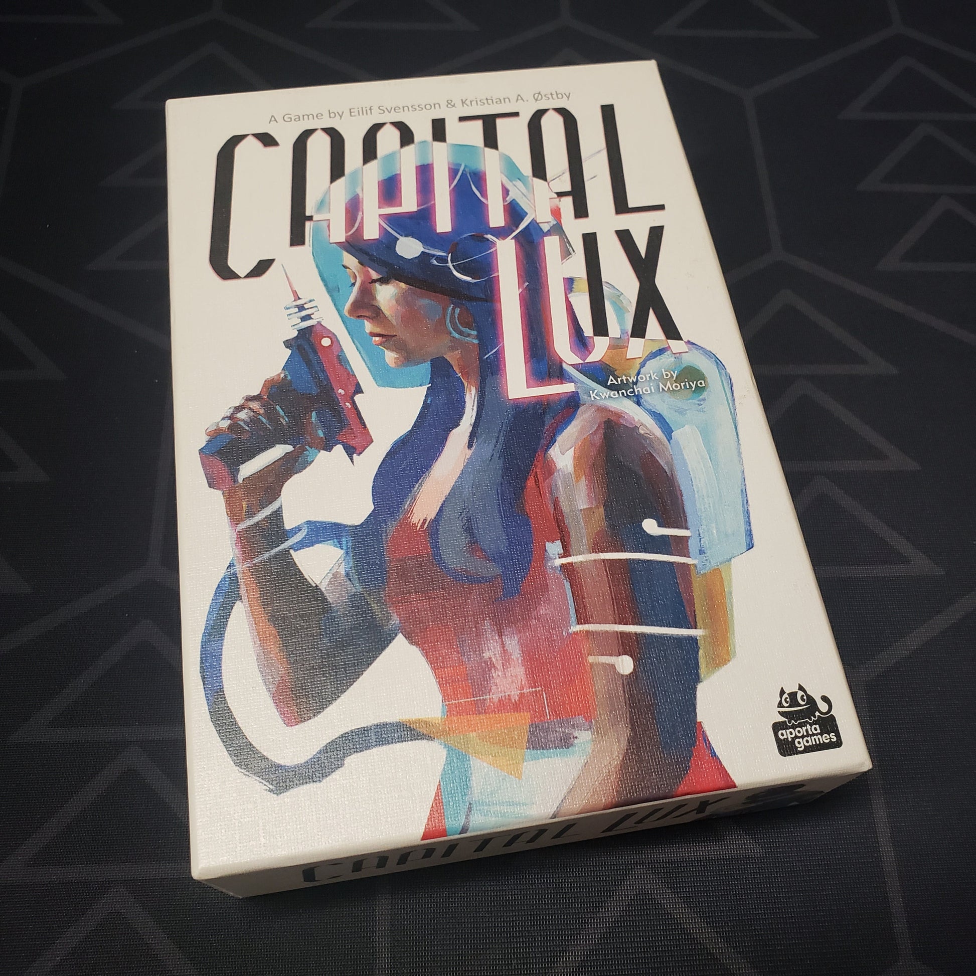 Image shows the front cover of the box for the Capital Lux card game