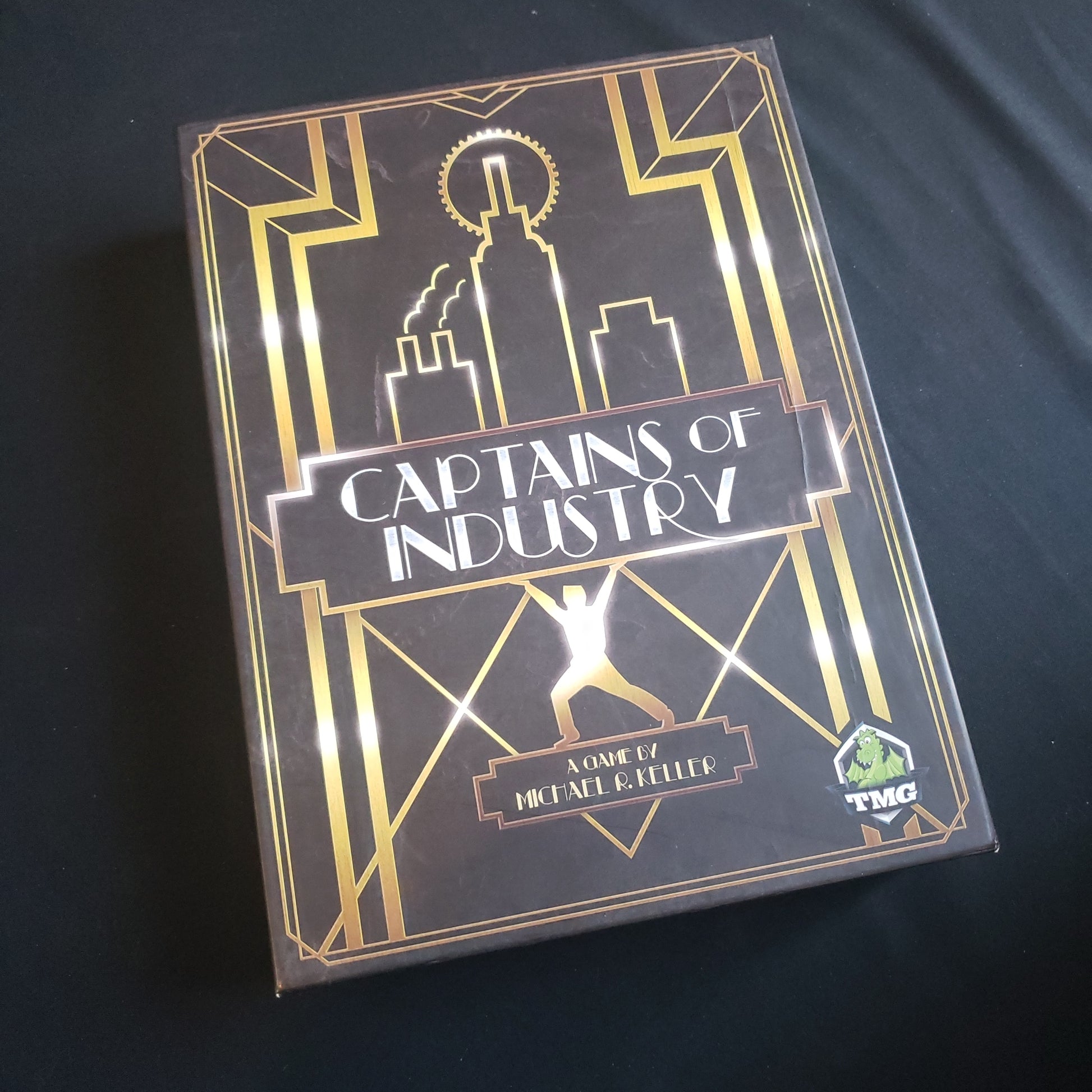 Image shows the front cover of the box of the Captains of Industry board game