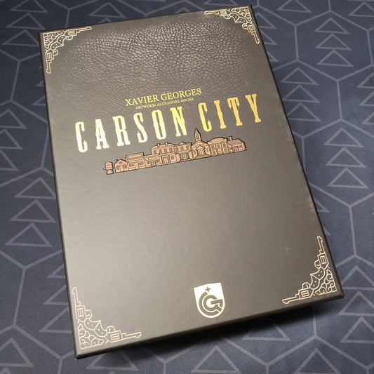 Image shows the front cover of the Big Box Edition of the board game Carson City