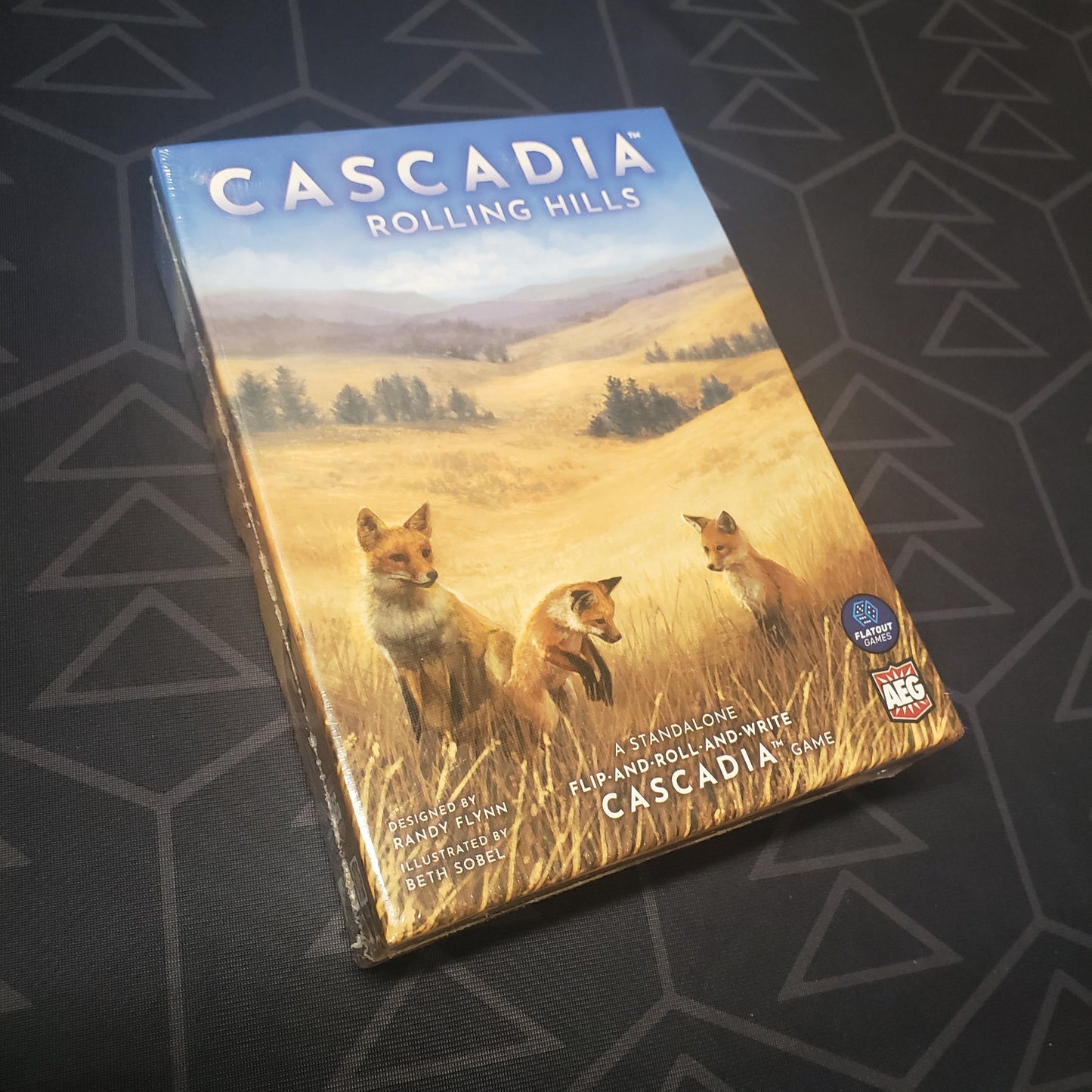 Image shows the front cover of the box for the Cascadia: Rolling Hills board game