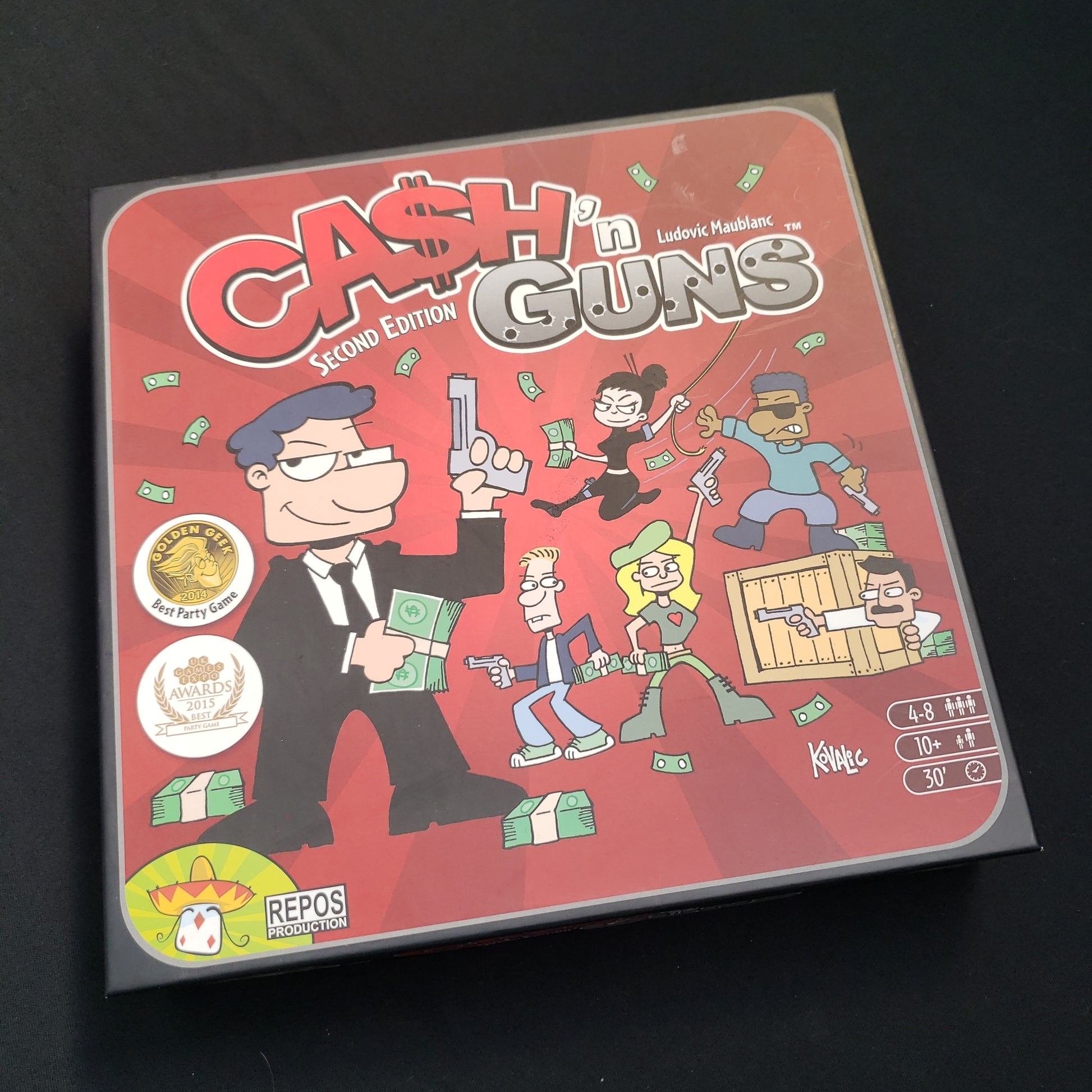 Image shows the front cover of the box of the Cash N Guns board game