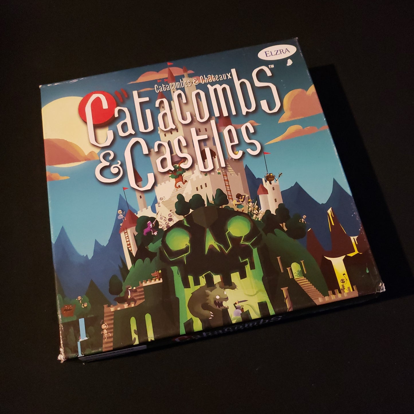 Image shows the front cover of the box of the Catacombs & Castles board game