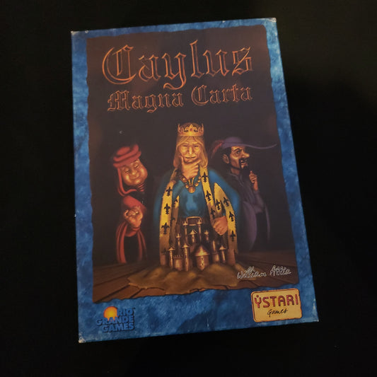 Image shows the front cover of the box of the Caylus Magna Carta card game