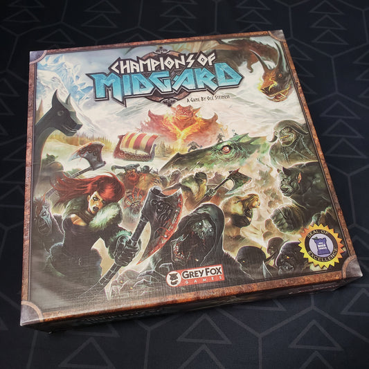 Image shows the front cover of the box of the Champions of Midgard board game