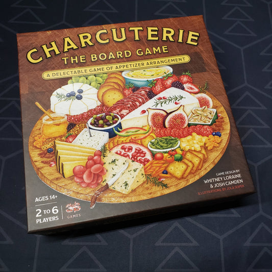 Image shows the front cover of the box for Charcuterie: The Board Game