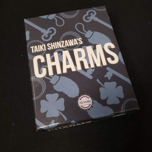 Image shows the front cover of the box of the Charms card game