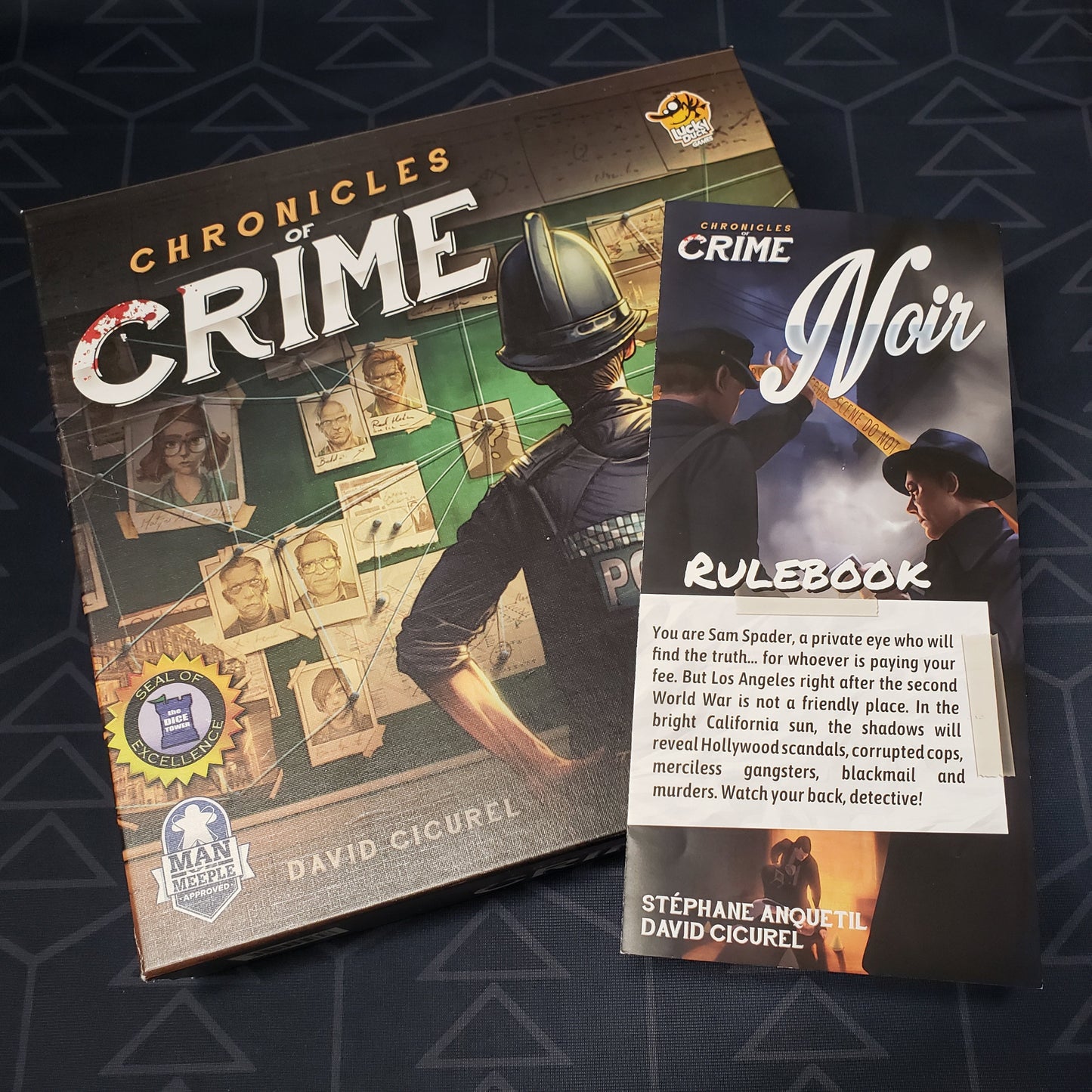 Image shows the front cover of the box of the Chronicles of Crime board game with the instructions for the Noir expansion sitting on top of it