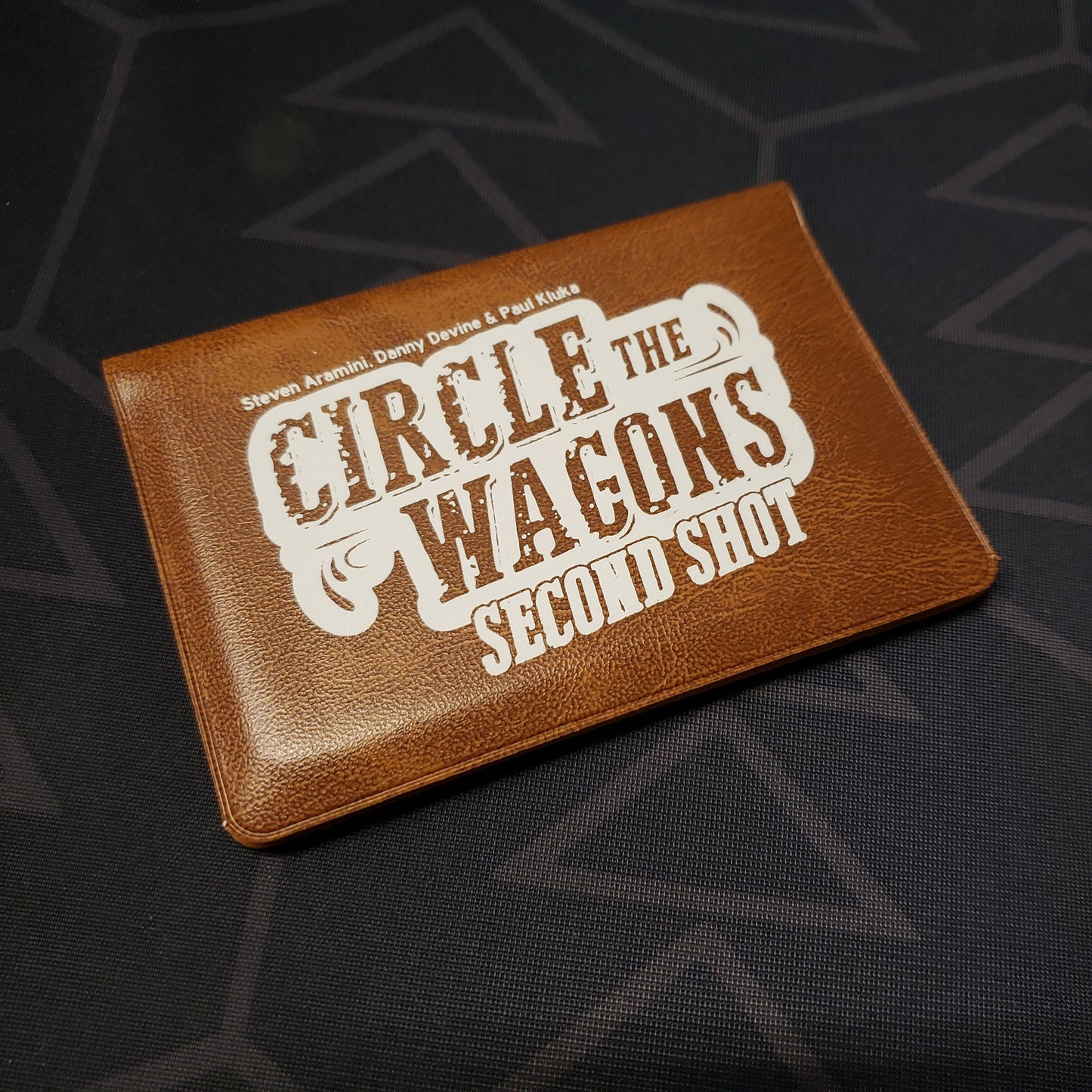 Image shows the front of the card wallet for the Circle the Wagons: Second Shot card game