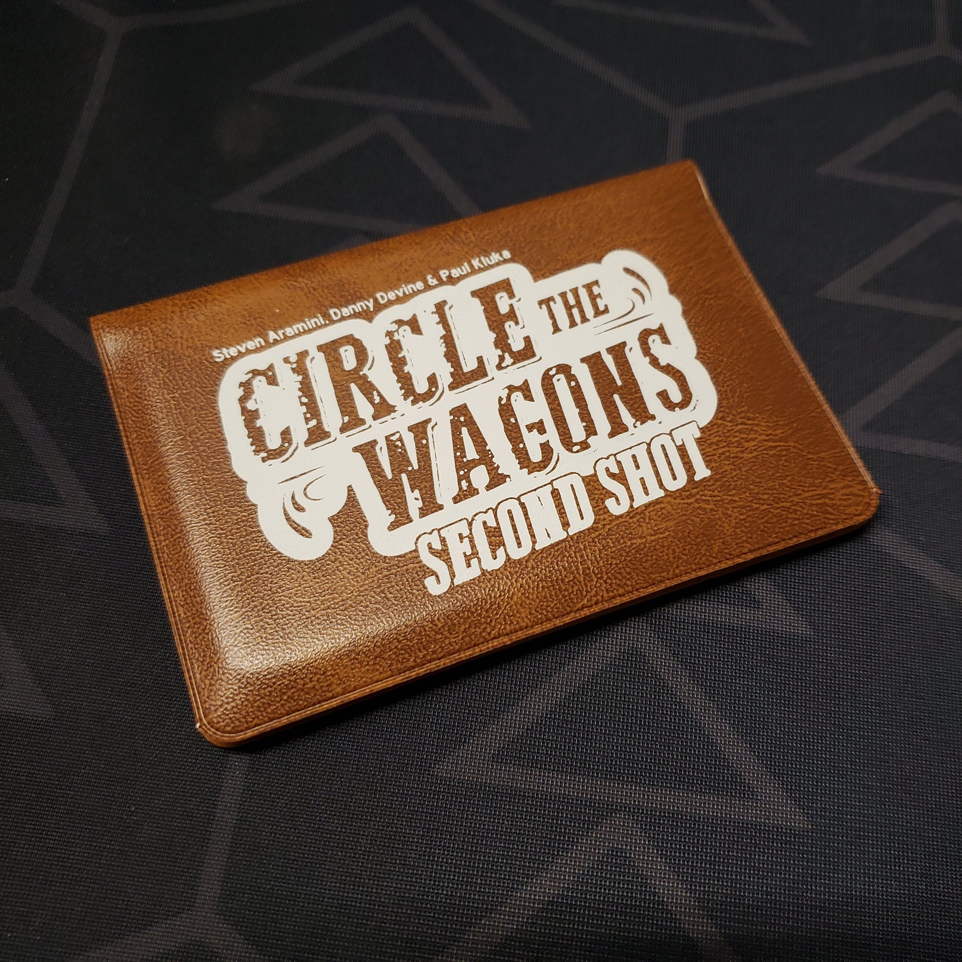 Image shows the front of the card wallet for the Circle the Wagons: Second Shot card game