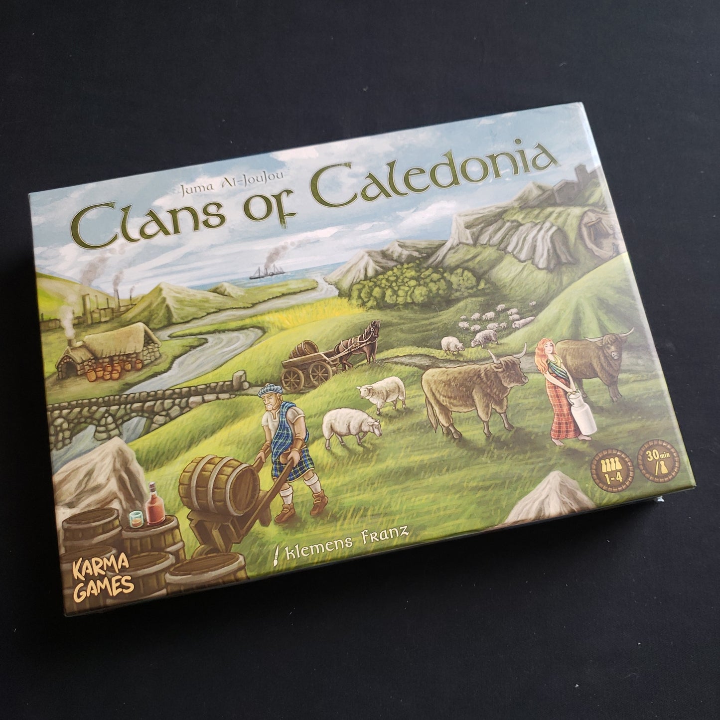 Image shows the front cover of the box of the Clans of Caledonia board game