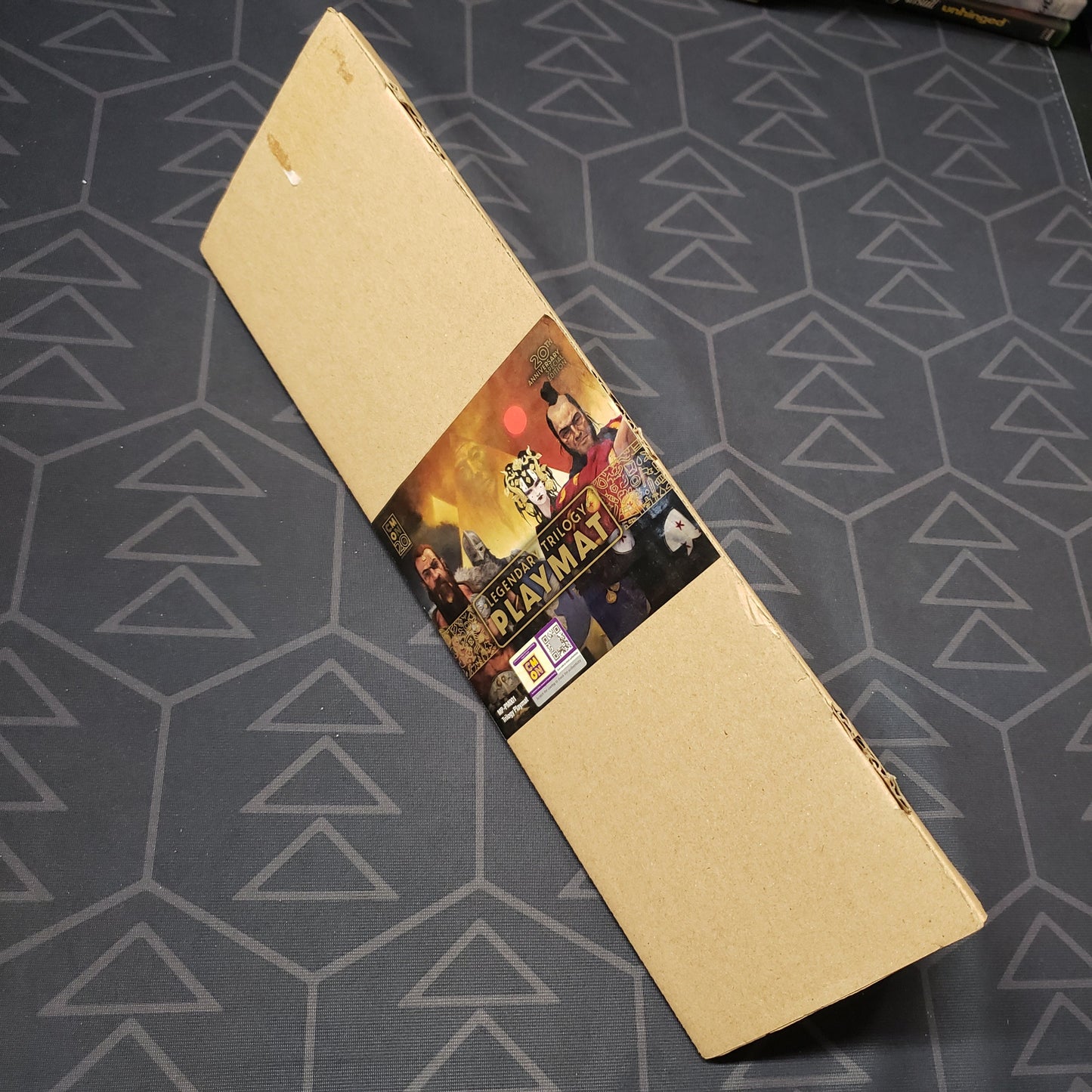Image shows the label side of the triangular box for the CMON Legendary Trilogy Playmat