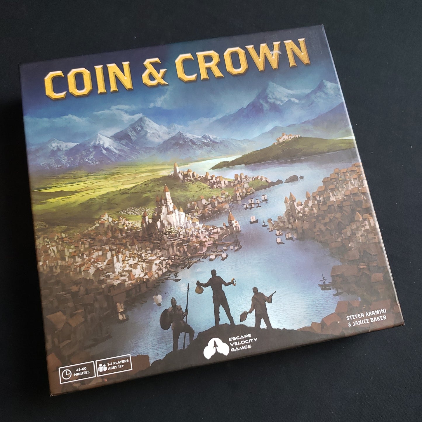 Image shows the front cover of the box of the Coin & Crown board game