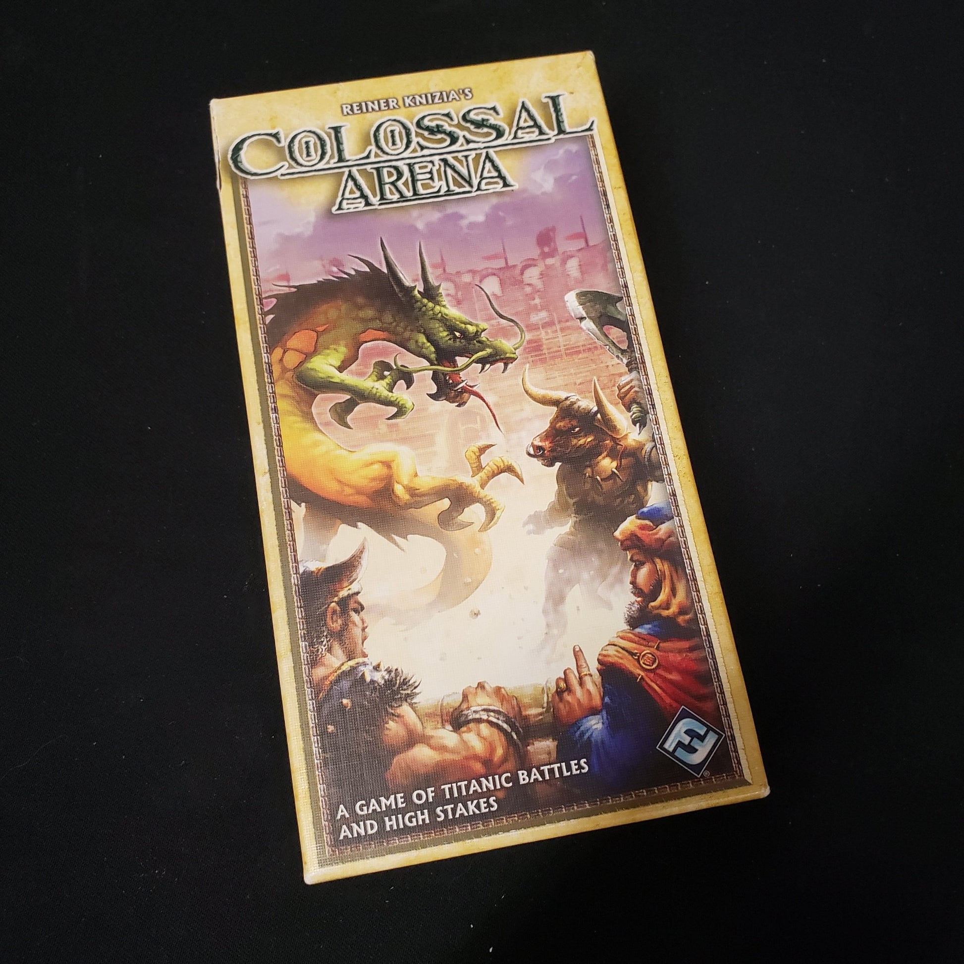 Image shows the front cover of the box of the Colossal Arena card game