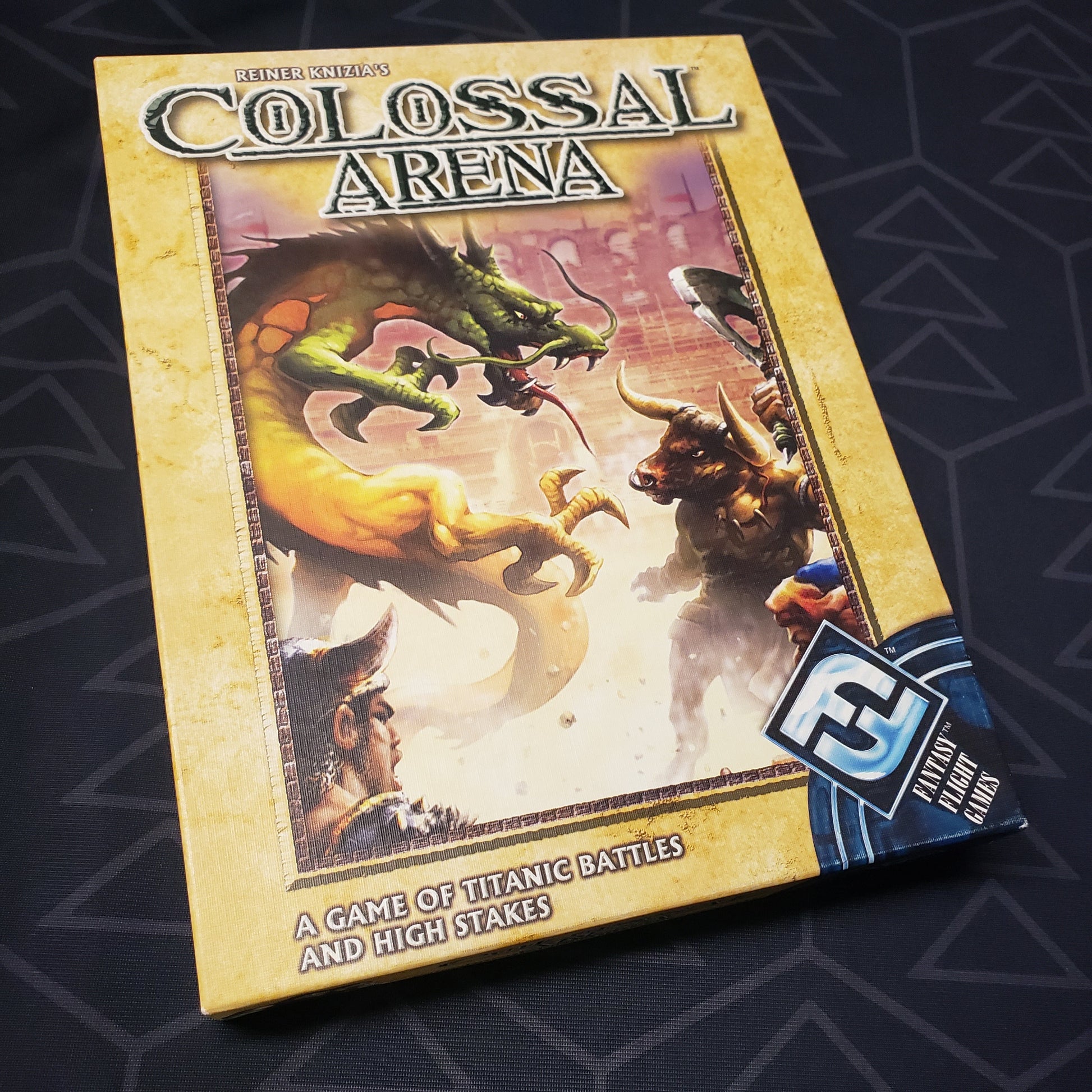 Image shows the front cover of the box of the Colossal Arena card game