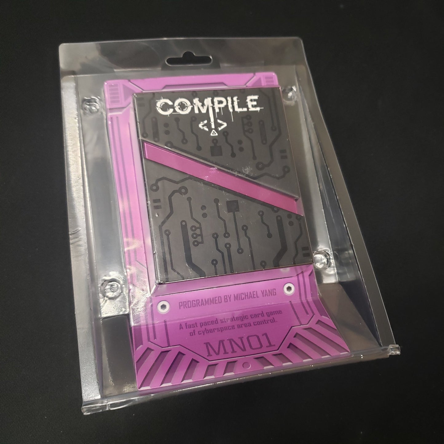 Image shows the front of the package of the card game Compile: Main 1