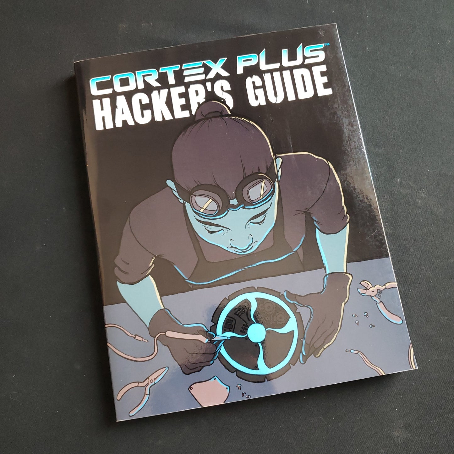 Image shows the front cover of the Cortex Plus: Hacker's Guide roleplaying game book