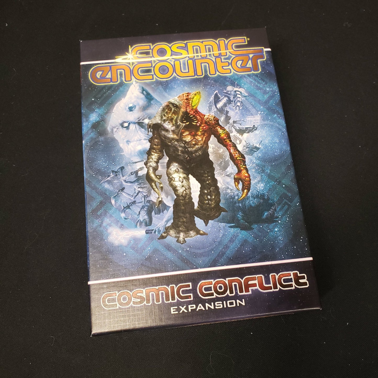 Image shows the front cover of the box for the Cosmic Conflict expansion from the board game Cosmic Encounter