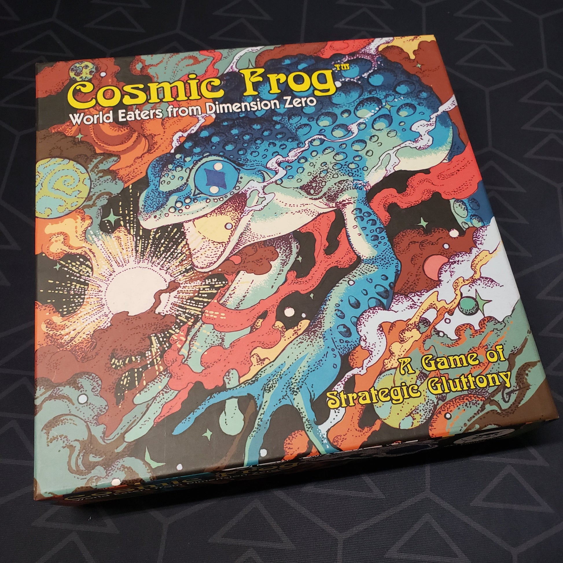 Image shows the front cover of the box for the Cosmic Frog board game