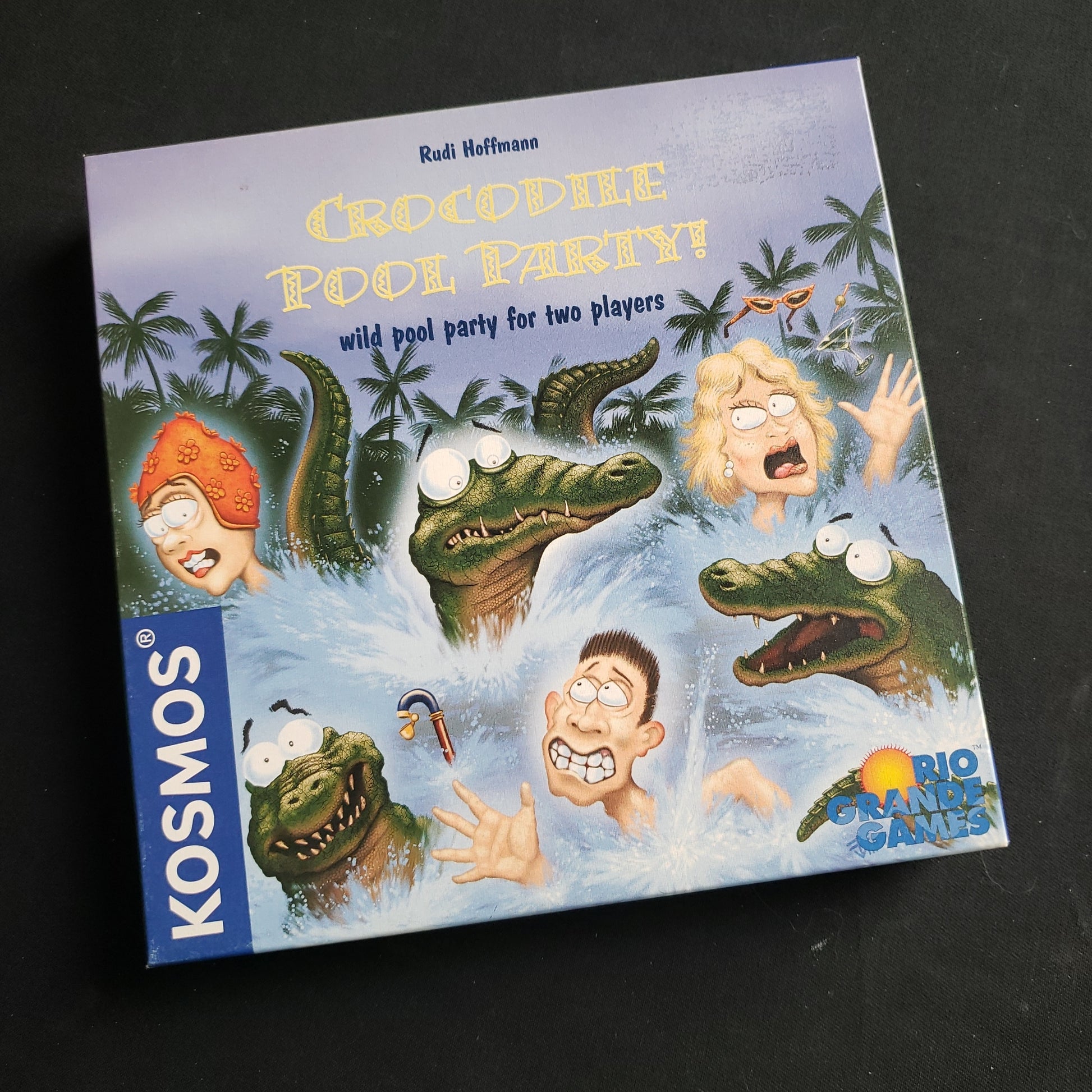 Image shows the front cover of the box of the Crocodile Pool Party board game