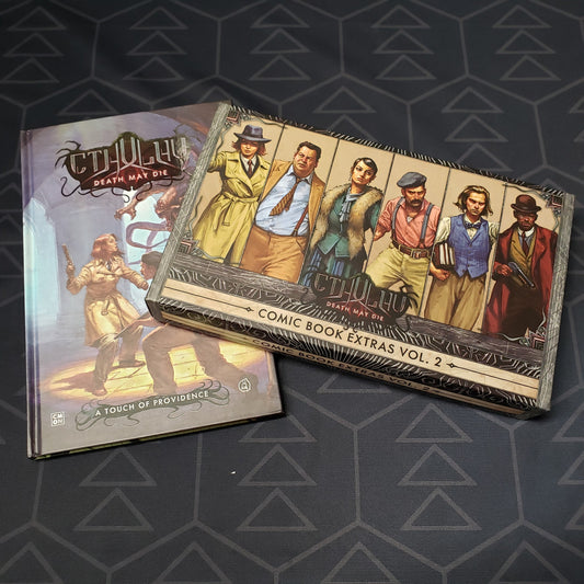 Image shows the front covers of the box for the Comic Book Extras Vol. 2expansion for the board game Cthulhu: Death May Die, as well as the "A Touch of Providence" graphic novel