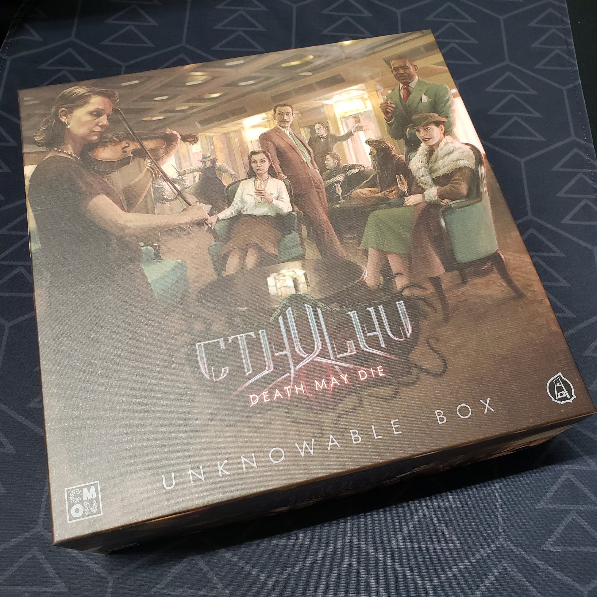 Image shows the front cover of the box of the Unknowable Box expansion for the board game Cthulhu: Death May Die