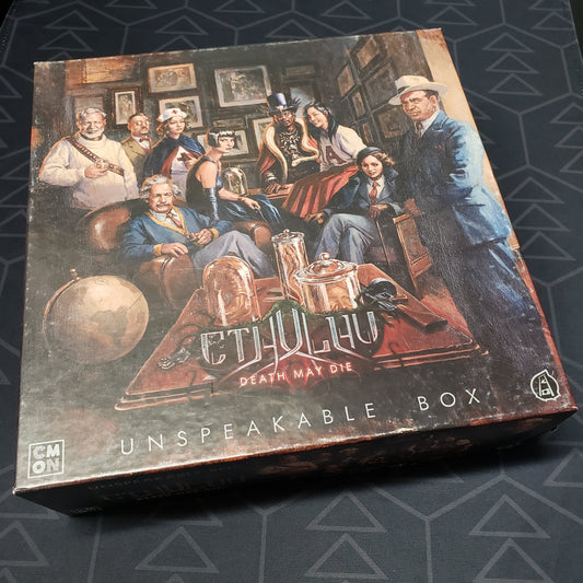 Image shows the front cover of the box of the Unspeakable Box expansion for the board game Cthulhu: Death May Die