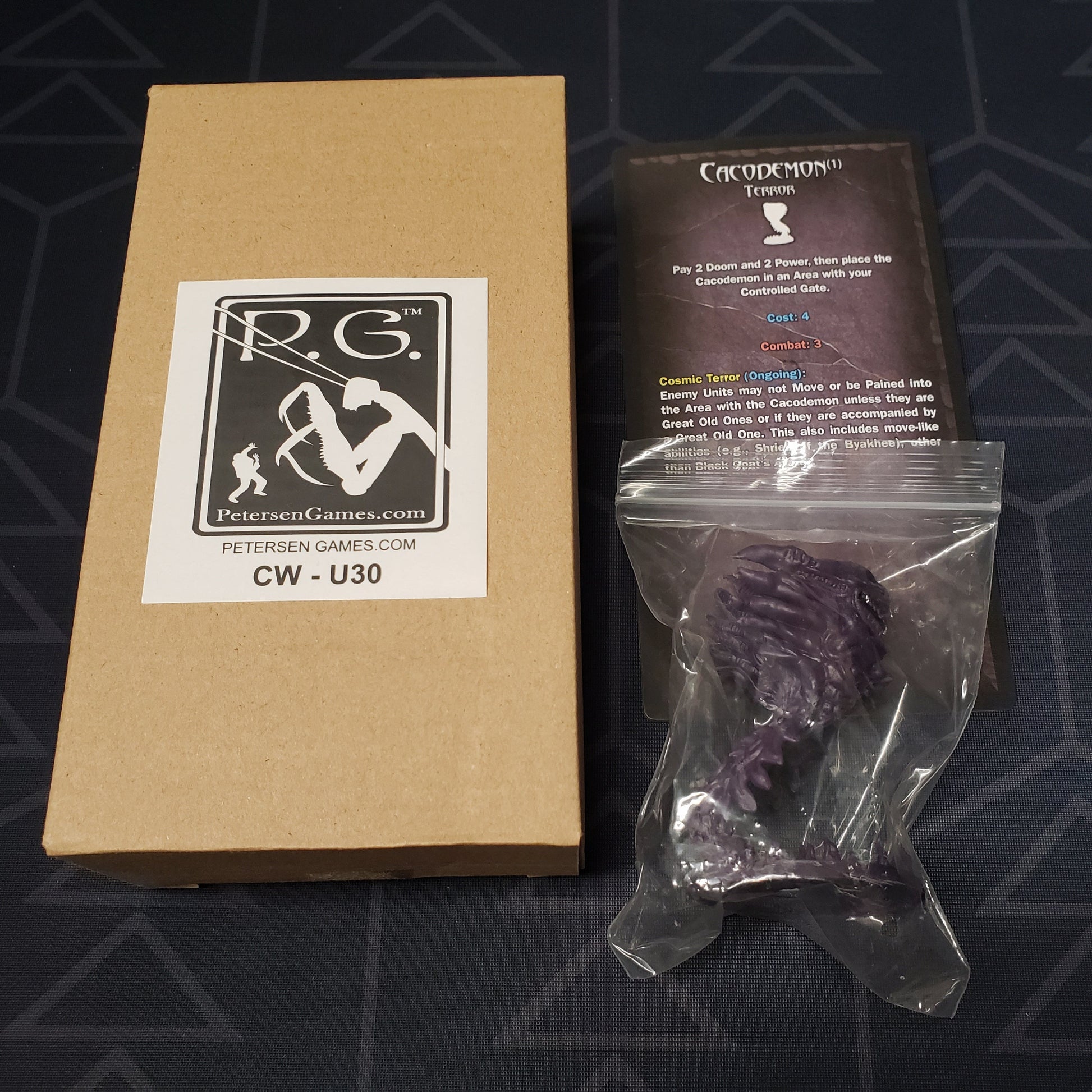 Image shows the cardboard box, miniature and cards for the Cacodemon expansion for the board game Cthulhu Wars