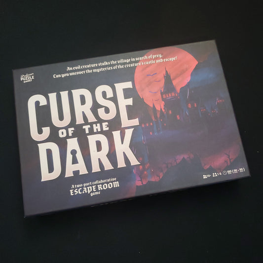 Image shows the front cover of the box of the Curse of the Dark escape room board game