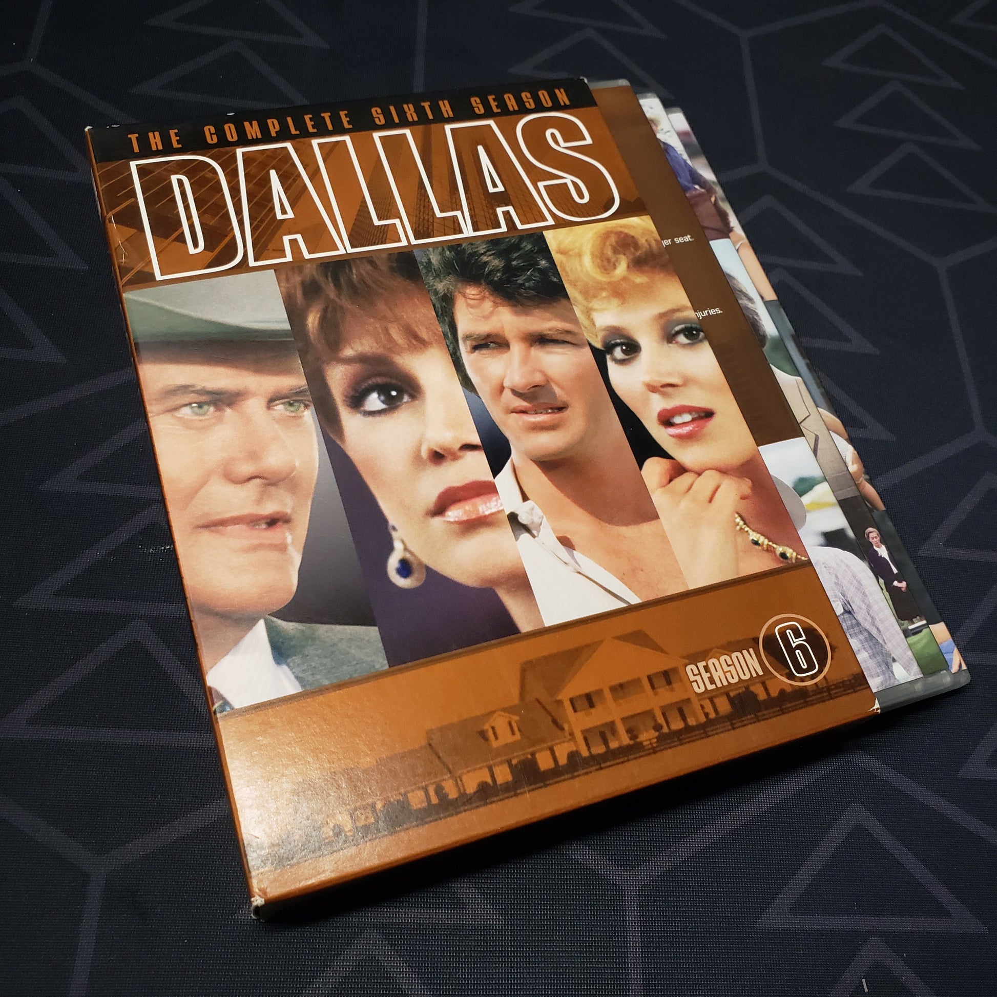 Image shows the outer box & three fanned-out disc cases for the sixth season of Dallas on DVD