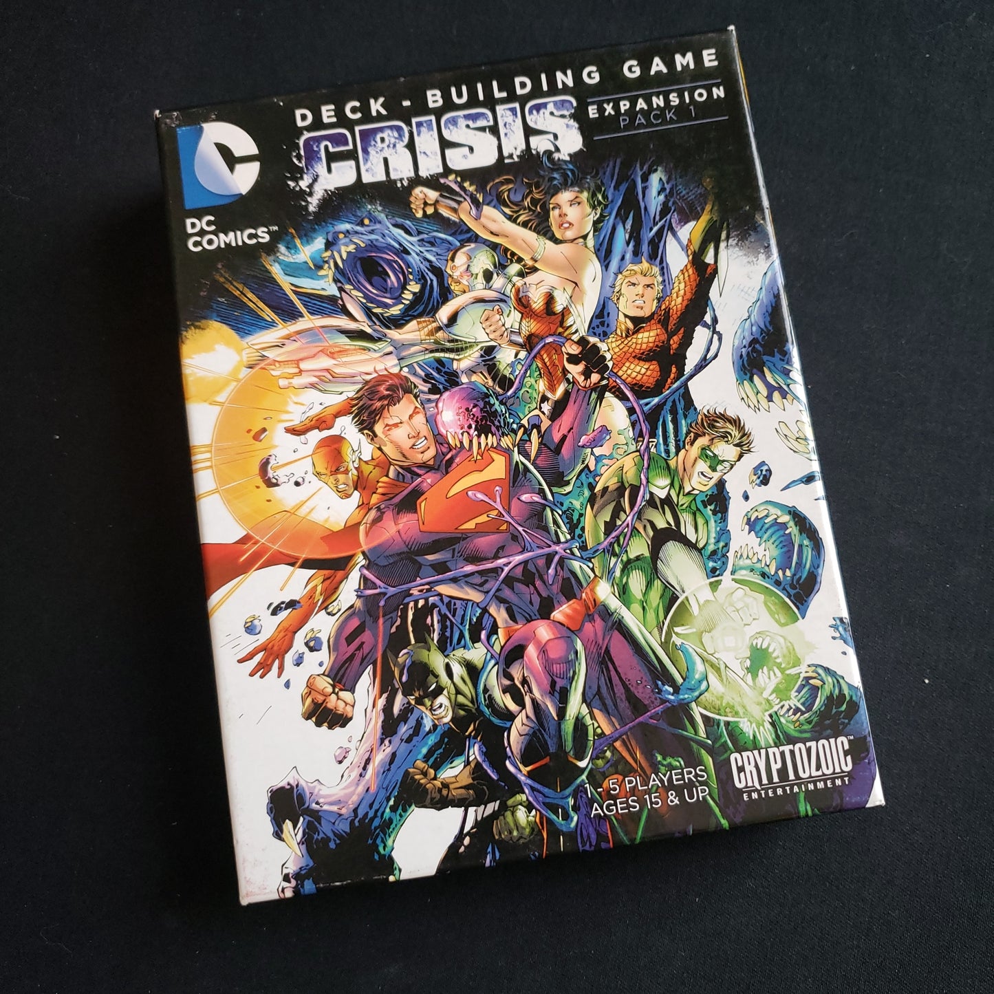 Image shows the front cover of the box of the Crisis Pack 1 expansion for the DC Comics Deckbuilding card game