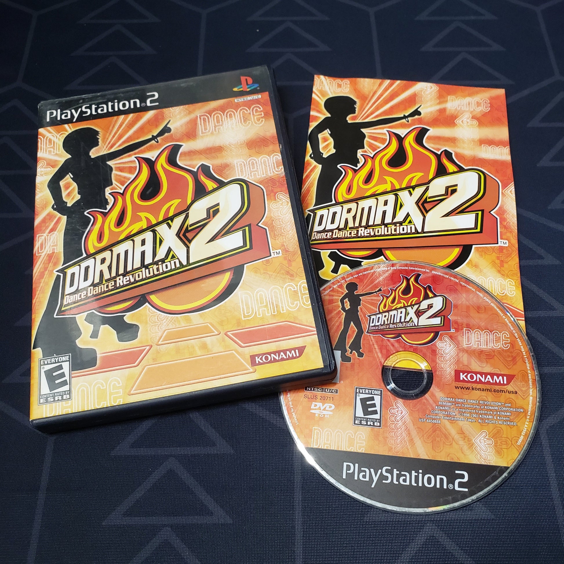 Image shows the case, manual & disc for the video game DDRMX2: Dance Dance Revolution for Playstation 2