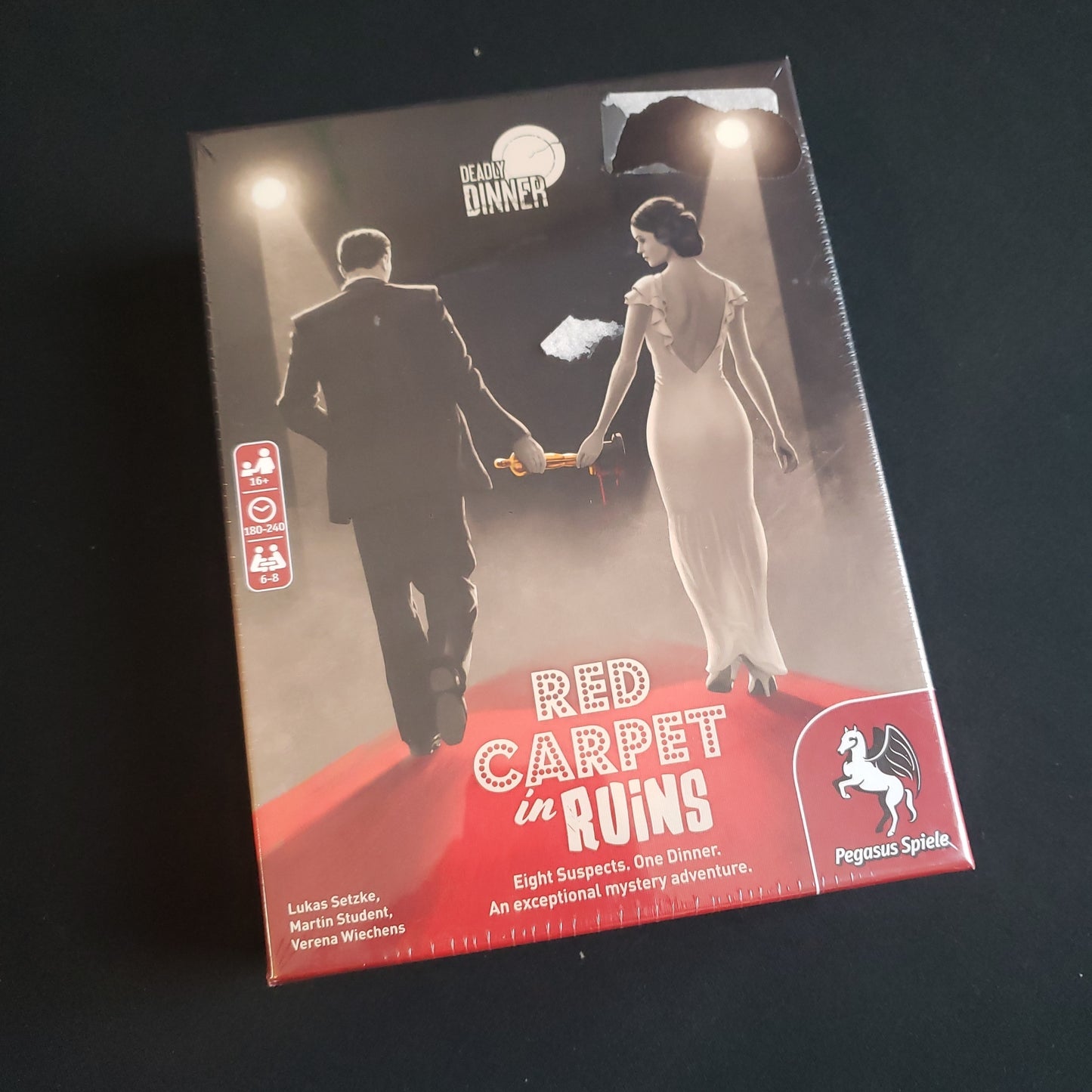 Image shows the front cover of the box of the Deadly Dinner: Red Carpet in Ruins party game